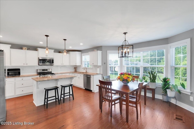 dining space with sink, a notable chandelier, and dark hardwood / wood-style floors