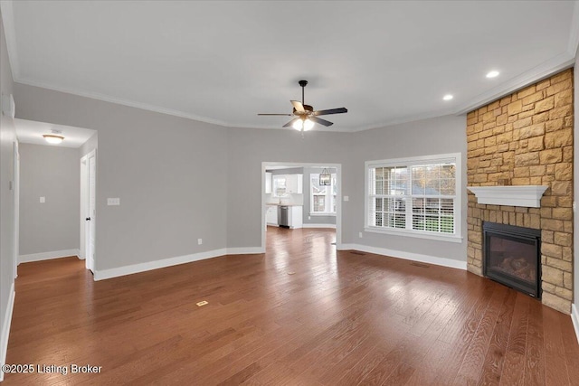 unfurnished living room featuring a fireplace, ceiling fan, crown molding, and dark wood-type flooring