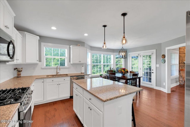 kitchen featuring a kitchen island, white cabinets, and sink