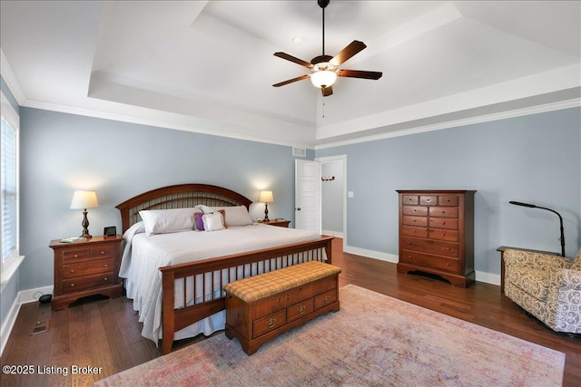 bedroom with ceiling fan, crown molding, dark hardwood / wood-style flooring, and a raised ceiling