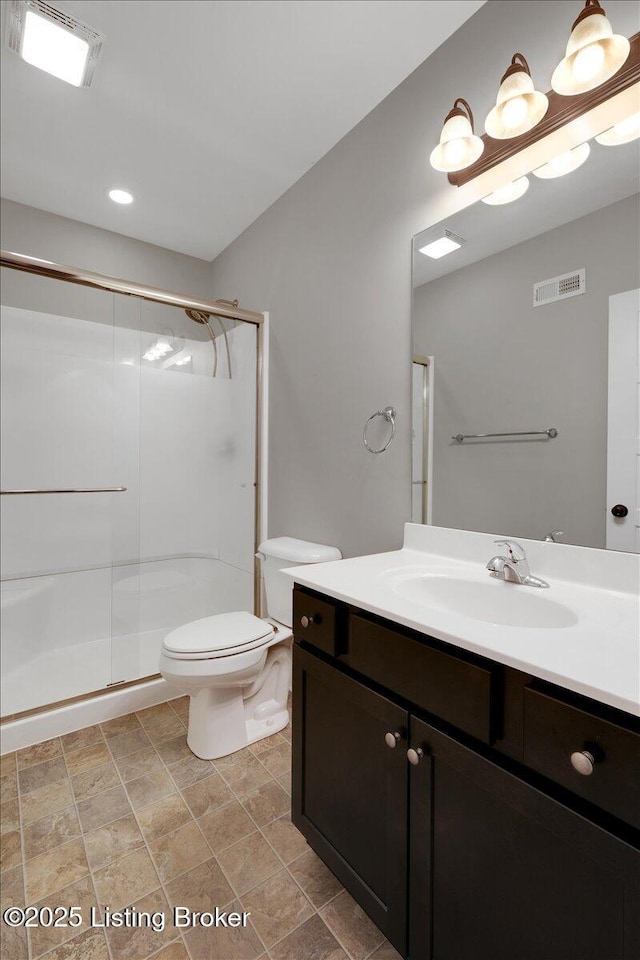 bathroom featuring an enclosed shower, vanity, and toilet