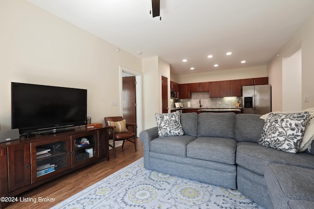 living room featuring sink and light hardwood / wood-style flooring