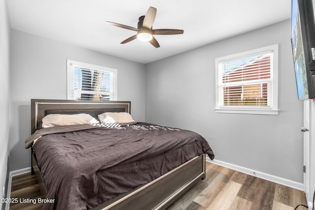 bedroom featuring ceiling fan, wood-type flooring, and multiple windows