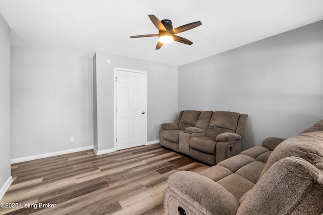 living room featuring dark wood-type flooring and ceiling fan