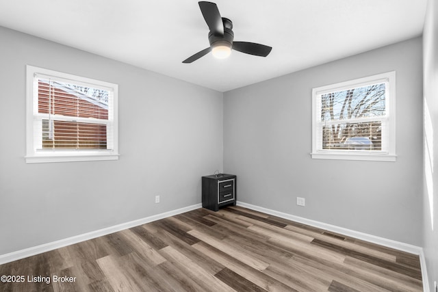 empty room featuring ceiling fan, hardwood / wood-style floors, and a healthy amount of sunlight