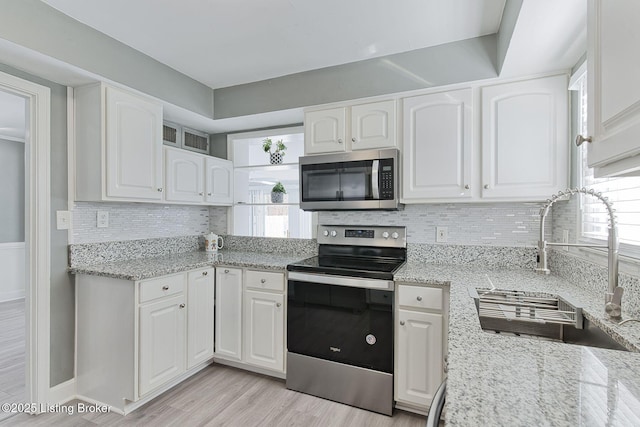 kitchen featuring stainless steel appliances, sink, and white cabinets