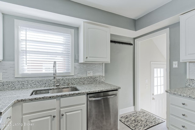 kitchen featuring stainless steel dishwasher, sink, decorative backsplash, and white cabinets