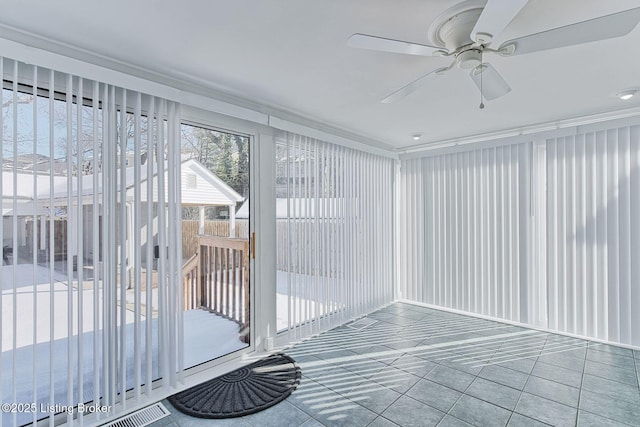 unfurnished sunroom with ceiling fan