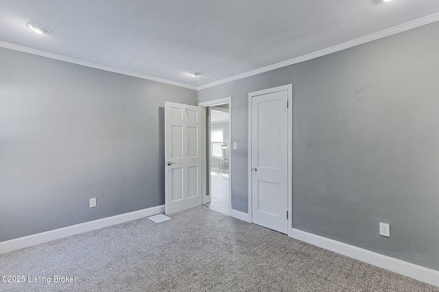 unfurnished room with crown molding and carpet flooring