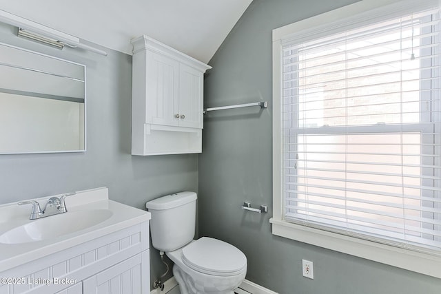 bathroom with vanity, lofted ceiling, and toilet