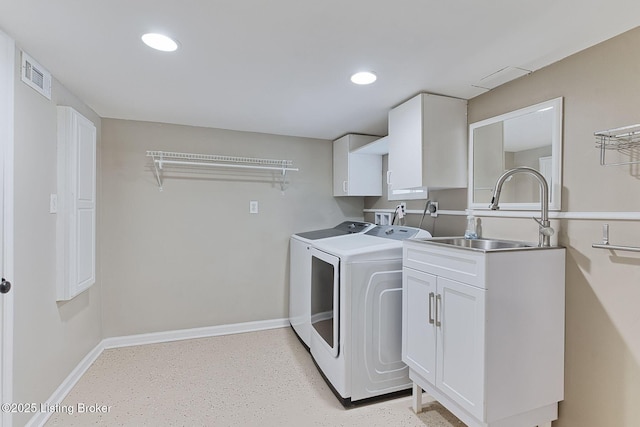 washroom featuring sink, washing machine and dryer, and cabinets