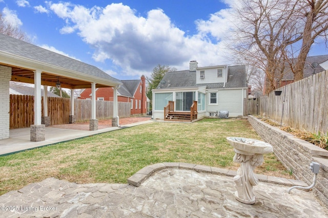 rear view of property featuring a patio area and a lawn