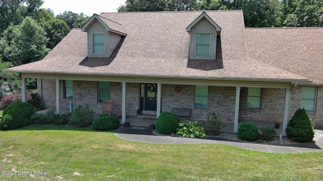 cape cod home featuring covered porch and a front lawn