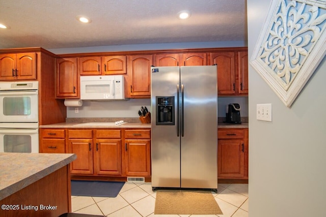 kitchen with white appliances and light tile patterned flooring