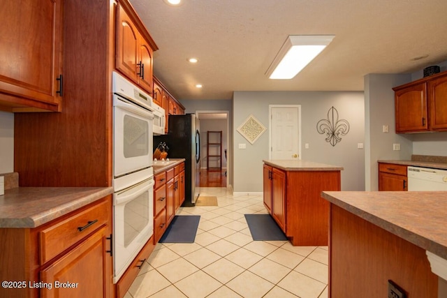 kitchen featuring white appliances, a kitchen island, and light tile patterned floors