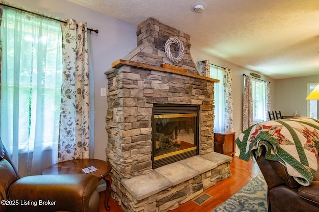 bedroom featuring a textured ceiling, a fireplace, and hardwood / wood-style flooring