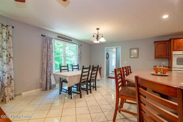 tiled dining room with an inviting chandelier