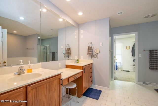 bathroom featuring tile patterned flooring, vanity, and a shower with shower door