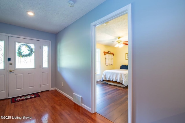 entryway with hardwood / wood-style flooring, a textured ceiling, and ceiling fan