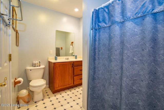 bathroom featuring toilet, vanity, and a shower with curtain