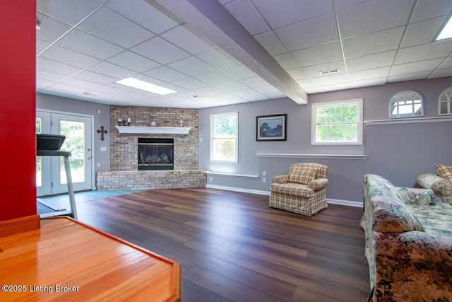 unfurnished living room featuring a brick fireplace and dark wood-type flooring