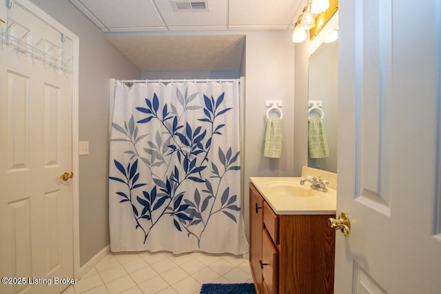 bathroom with vanity, a shower with shower curtain, tile patterned flooring, and a drop ceiling