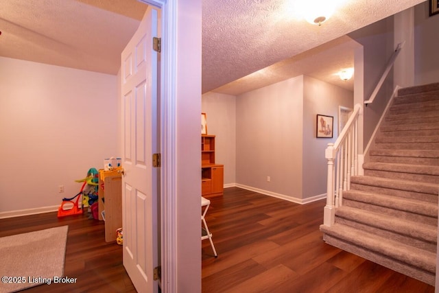 interior space featuring a textured ceiling and dark hardwood / wood-style flooring