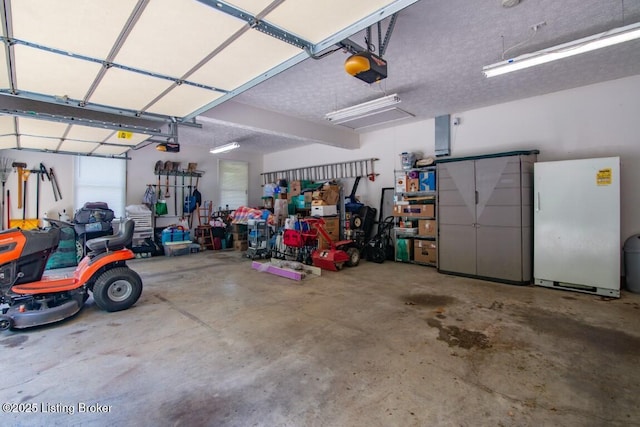 garage featuring white refrigerator and a garage door opener