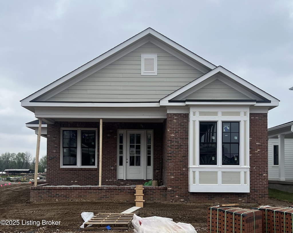 bungalow-style house with a porch and brick siding