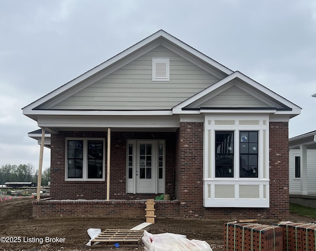 bungalow-style house with a porch and brick siding
