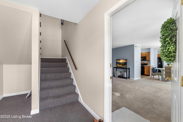 staircase with vaulted ceiling and carpet flooring