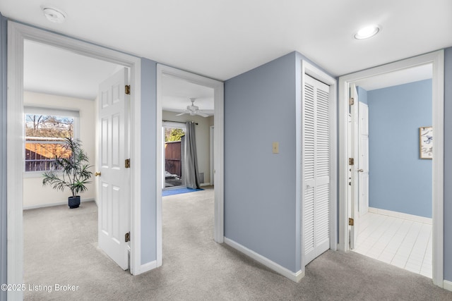 corridor featuring light colored carpet