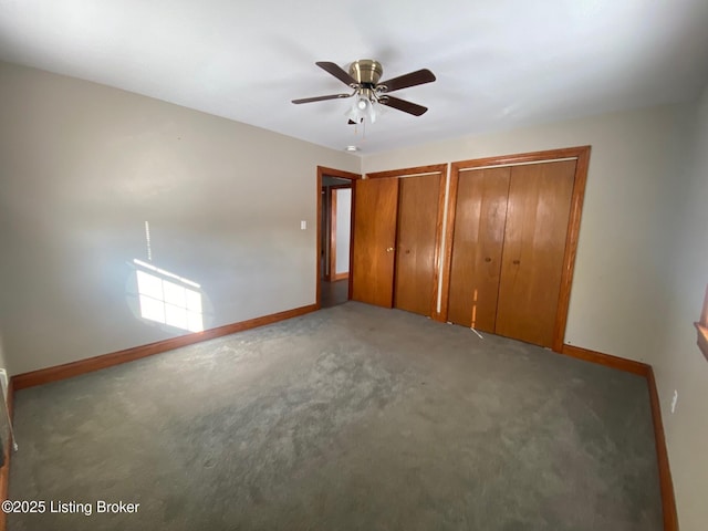 unfurnished bedroom with ceiling fan, carpet, and two closets