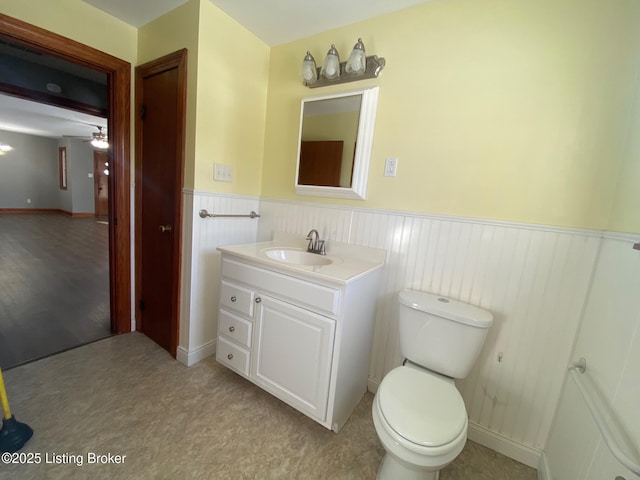 bathroom with toilet, ceiling fan, and vanity