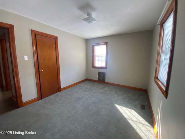 unfurnished bedroom with carpet floors and heating unit