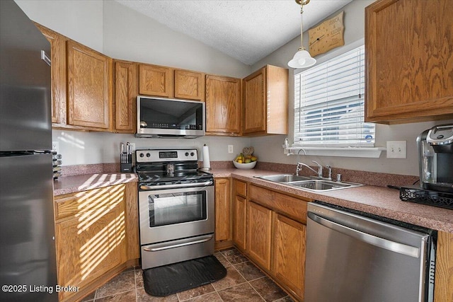 kitchen with stainless steel appliances, a textured ceiling, pendant lighting, sink, and lofted ceiling