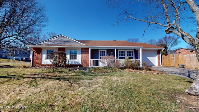 ranch-style home featuring a front lawn, driveway, fence, an attached garage, and brick siding