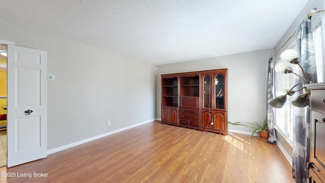 interior space featuring light wood-style flooring and baseboards