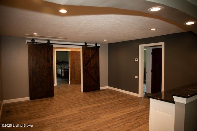 empty room featuring a barn door and hardwood / wood-style floors