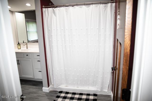 bathroom with wood-type flooring, vanity, and a shower with curtain