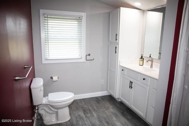 bathroom featuring toilet, hardwood / wood-style flooring, and vanity