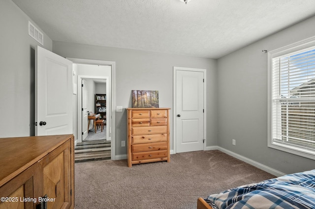 bedroom with dark carpet and a textured ceiling