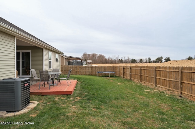 view of yard featuring a trampoline, a deck, and cooling unit