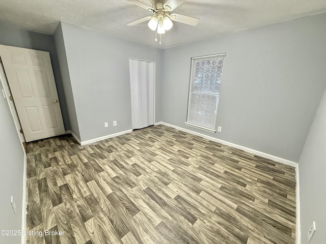 unfurnished bedroom featuring a closet, a textured ceiling, ceiling fan, and wood-type flooring