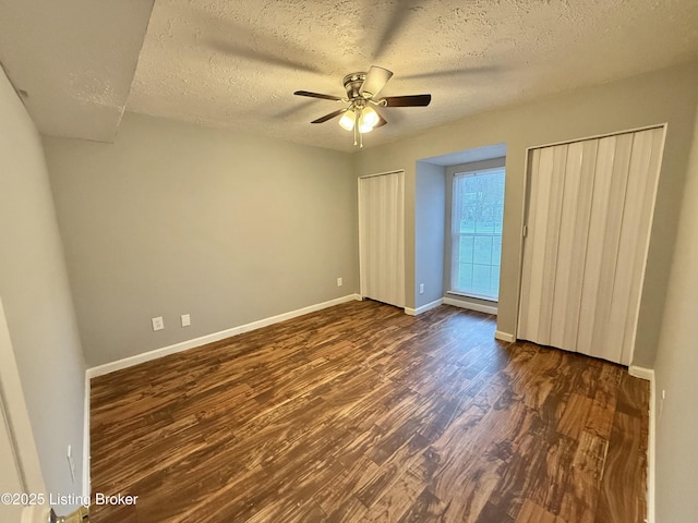 unfurnished bedroom featuring ceiling fan, dark wood-type flooring, and a textured ceiling