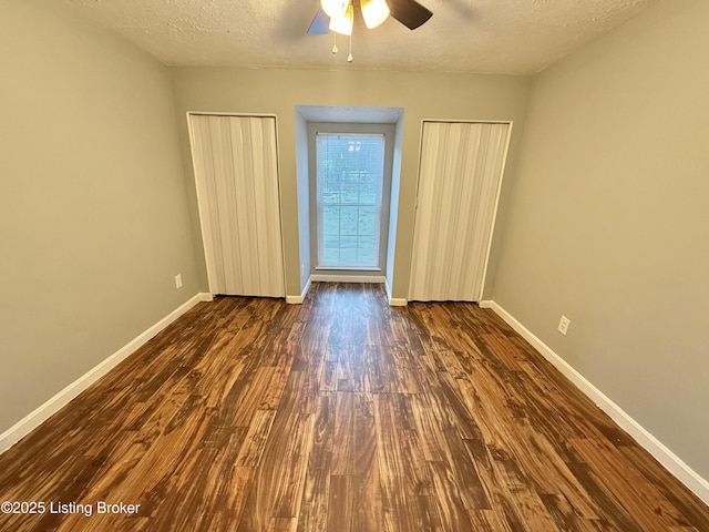 unfurnished bedroom with a textured ceiling, ceiling fan, and dark hardwood / wood-style floors