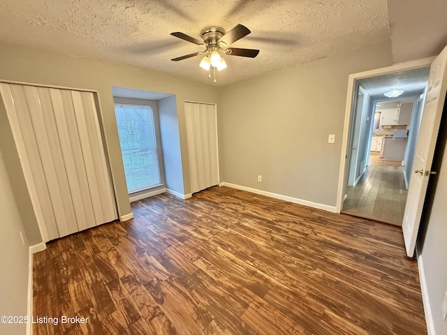 unfurnished bedroom featuring a textured ceiling, ceiling fan, and dark wood-type flooring