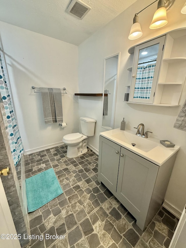 bathroom featuring toilet, vanity, and a textured ceiling