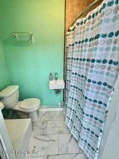 bathroom featuring a shower with curtain and toilet