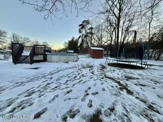 yard covered in snow featuring a trampoline